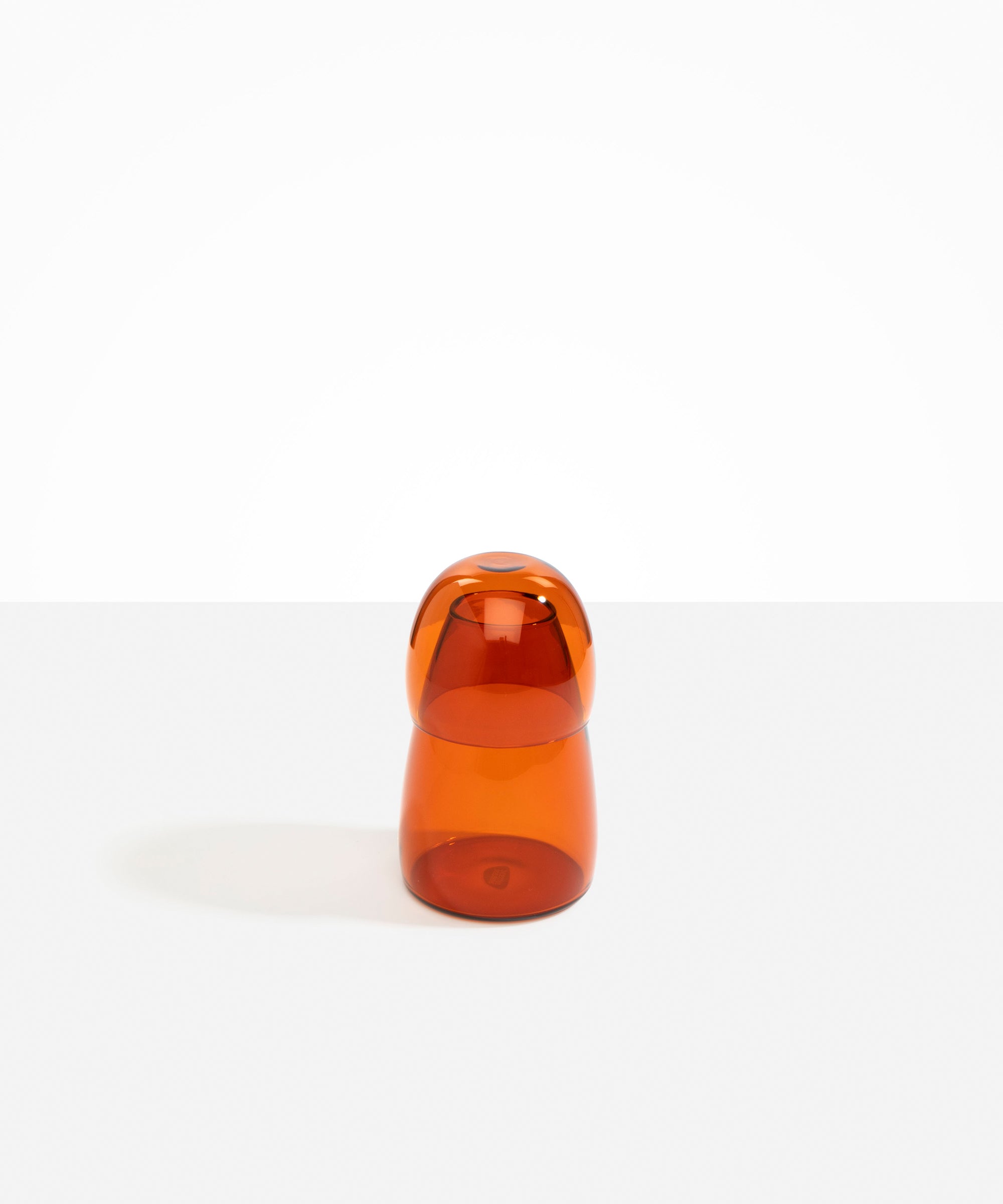 Dinosaur Designs colored Glass Pebble Carafe cup and jug set in amber orange.