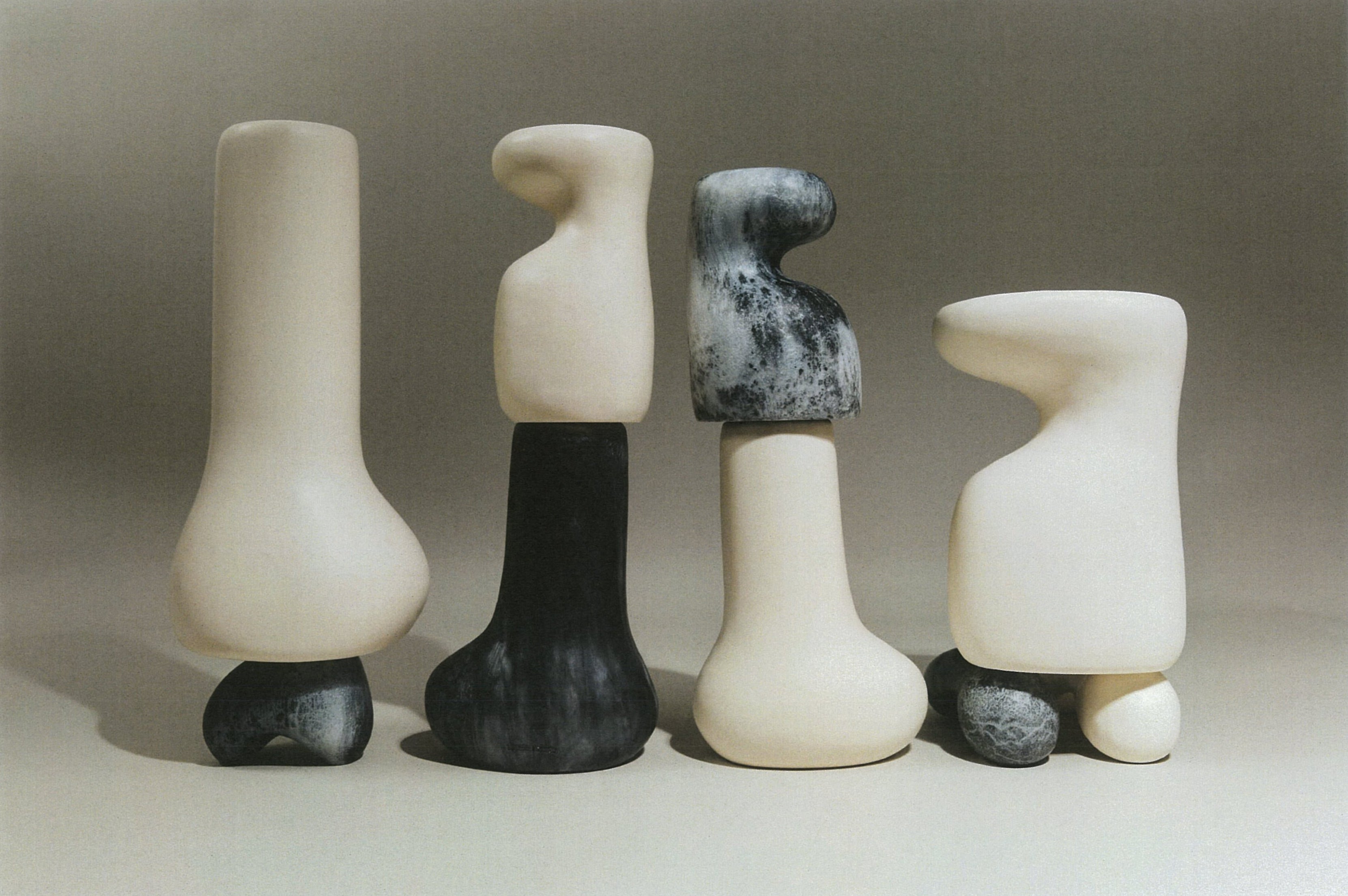 Abstract resin vases in cream and grey colourways, on a neutral background