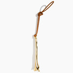 Dinosaur Designs Metal Flower Decoration in Brass — polished brass cast lily-shaped decoration with tan leather hanging loop