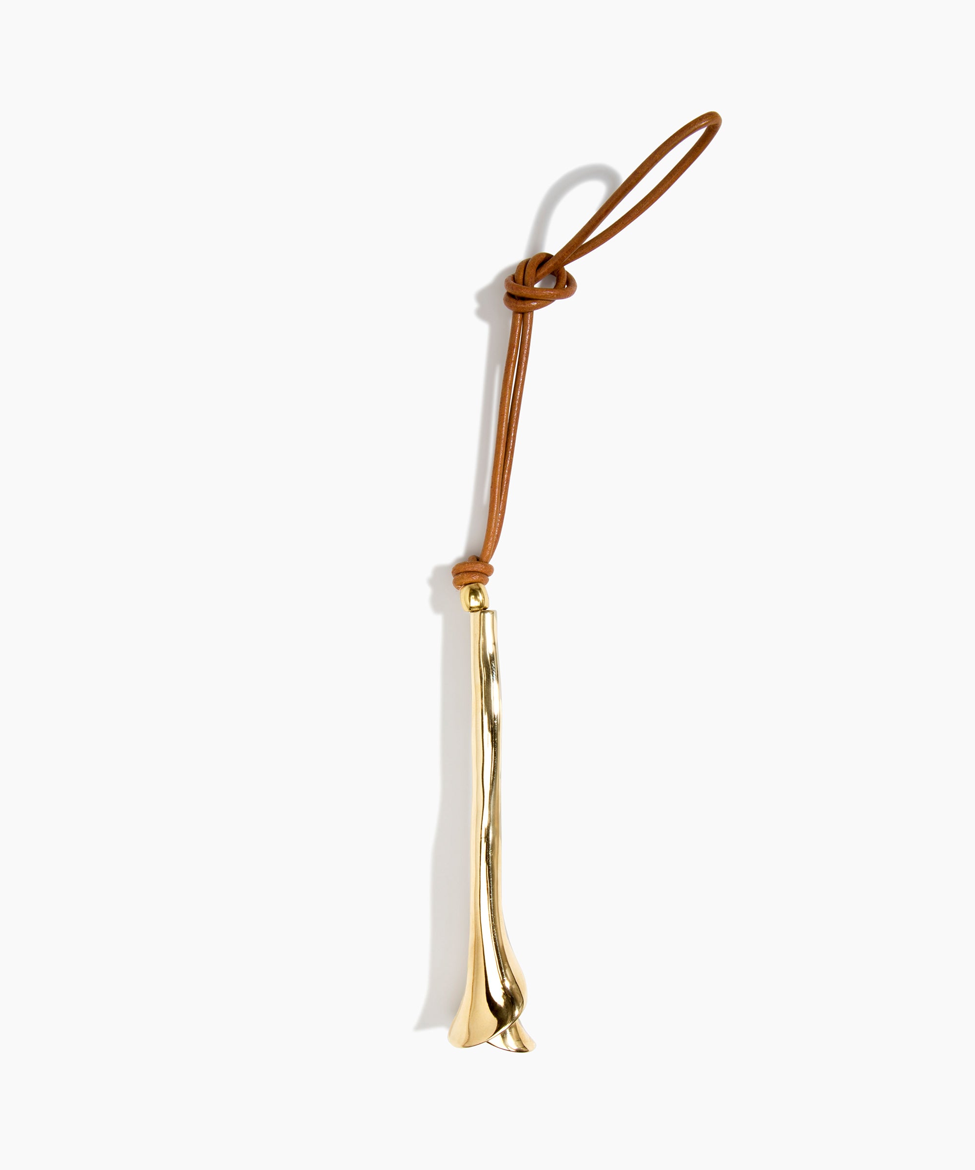 Dinosaur Designs Metal Flower Decoration in Brass — polished brass cast lily-shaped decoration with tan leather hanging loop