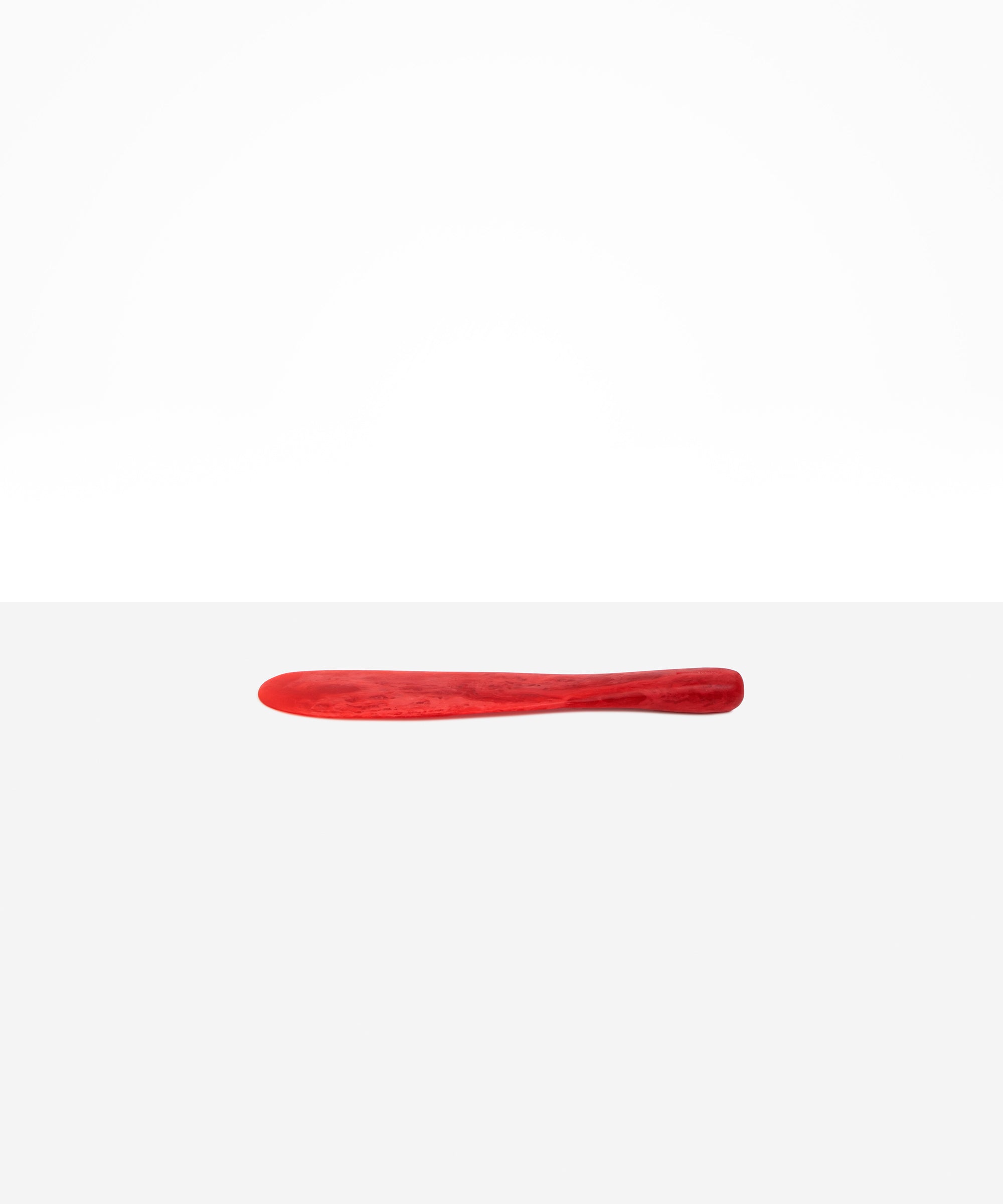 Dinosaur Designs Temple Cake Knife in Cranberry — handcrafted marbled red resin cake knife with smooth tapered blade and rounded handle.