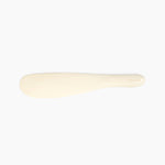 Dinosaur Designs Temple Cake Knife in Cream — handcrafted cream resin cake knife with smooth tapered blade and rounded handle.