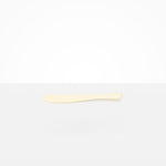 Dinosaur Designs Temple Cake Knife in Cream — handcrafted cream resin cake knife with smooth tapered blade and rounded handle.