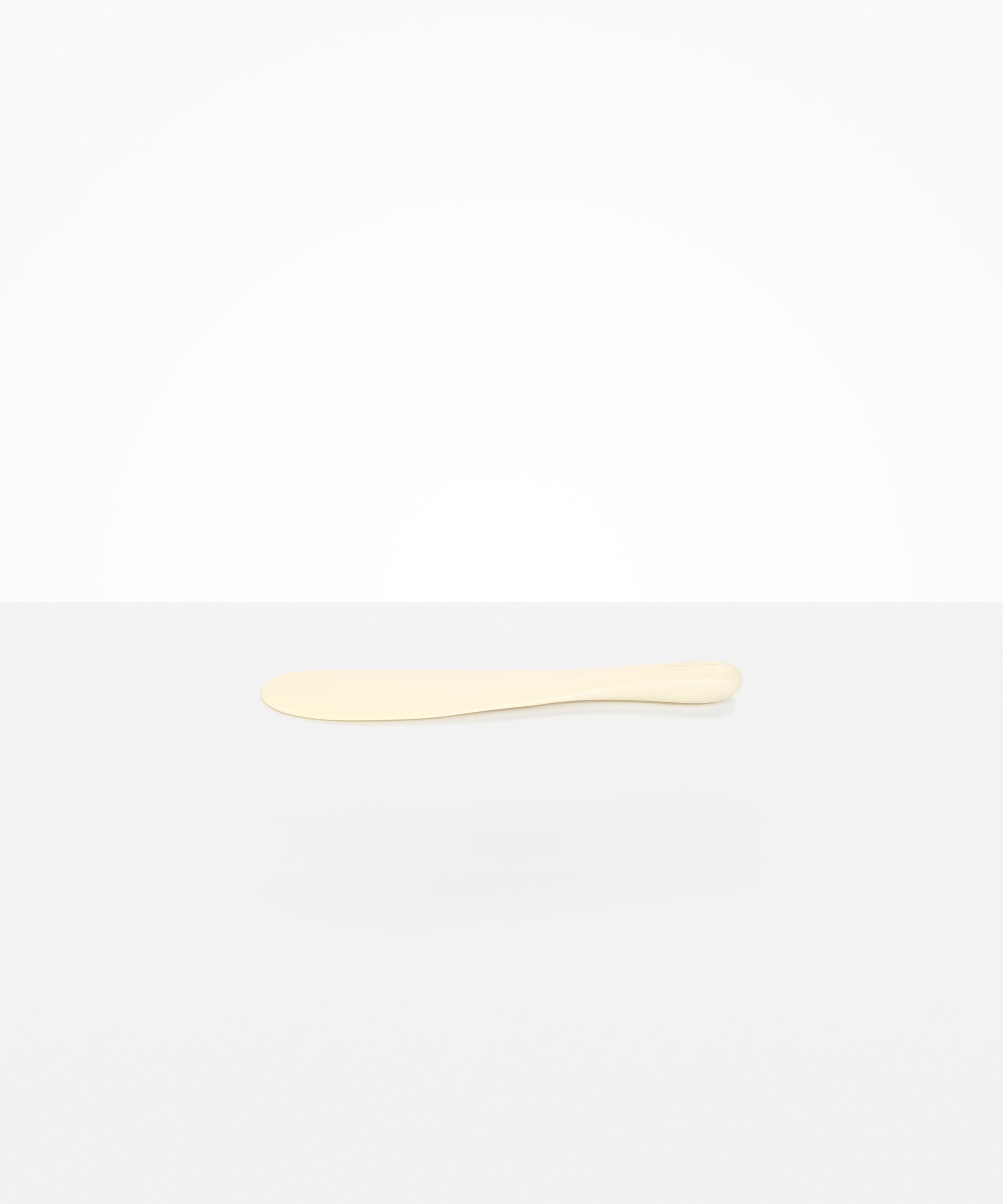 Dinosaur Designs Temple Cake Knife in Cream — handcrafted cream resin cake knife with smooth tapered blade and rounded handle.