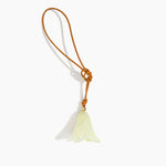 Dinosaur Designs Flower Bag Charm in Pistachio colour with Brass bead — handcrafted marbled pastel green resin bell-shaped flower bag charm with tan leather hanging loop and brass bead