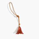 Dinosaur Designs Flower Bag Charm in Rust colour with Brass bead — handcrafted marbled terracotta red and cream resin bell-shaped flower bag charm with tan leather hanging loop and brass bead