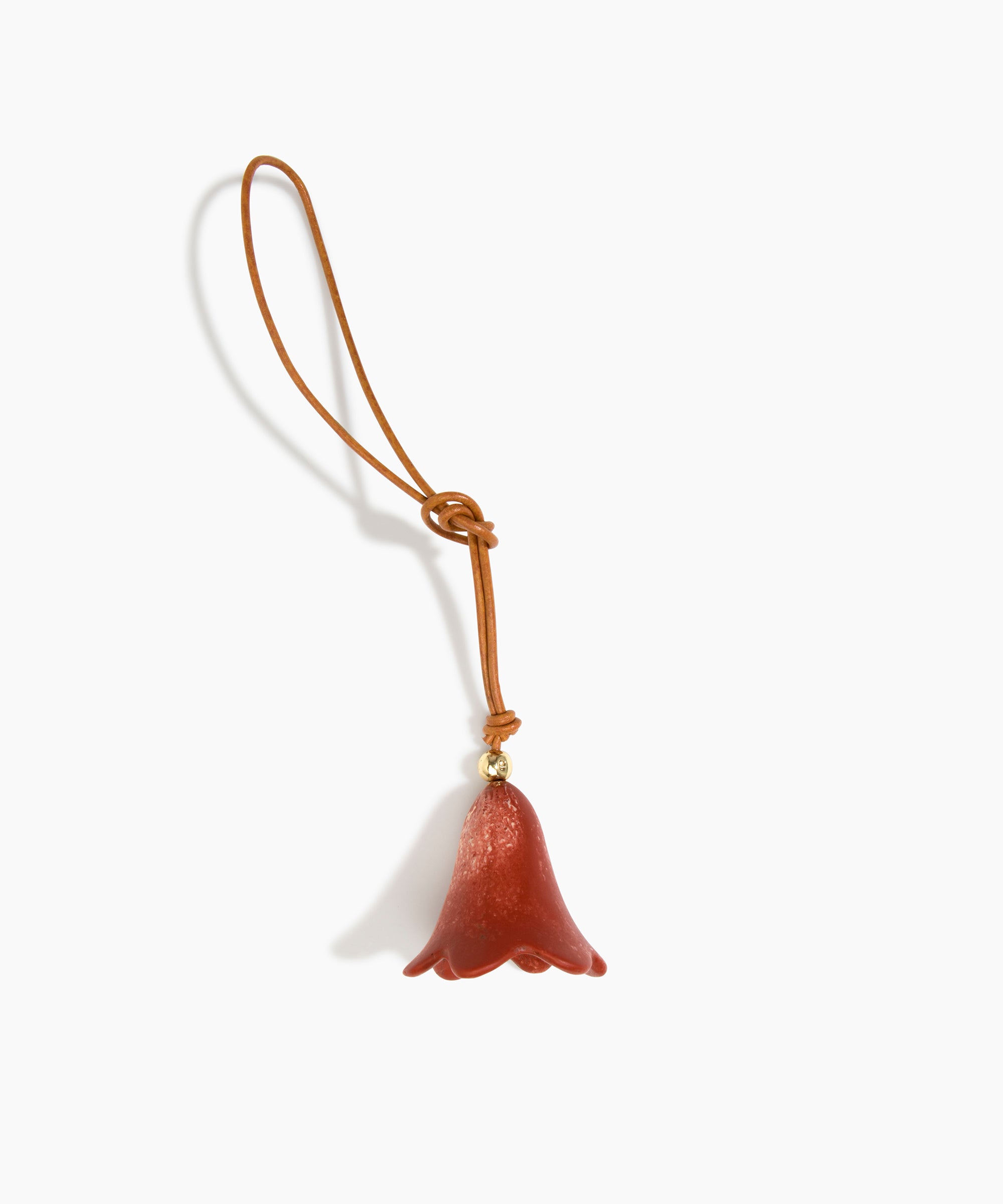 Dinosaur Designs Flower Bag Charm in Rust colour with Brass bead — handcrafted marbled terracotta red and cream resin bell-shaped flower bag charm with tan leather hanging loop and brass bead