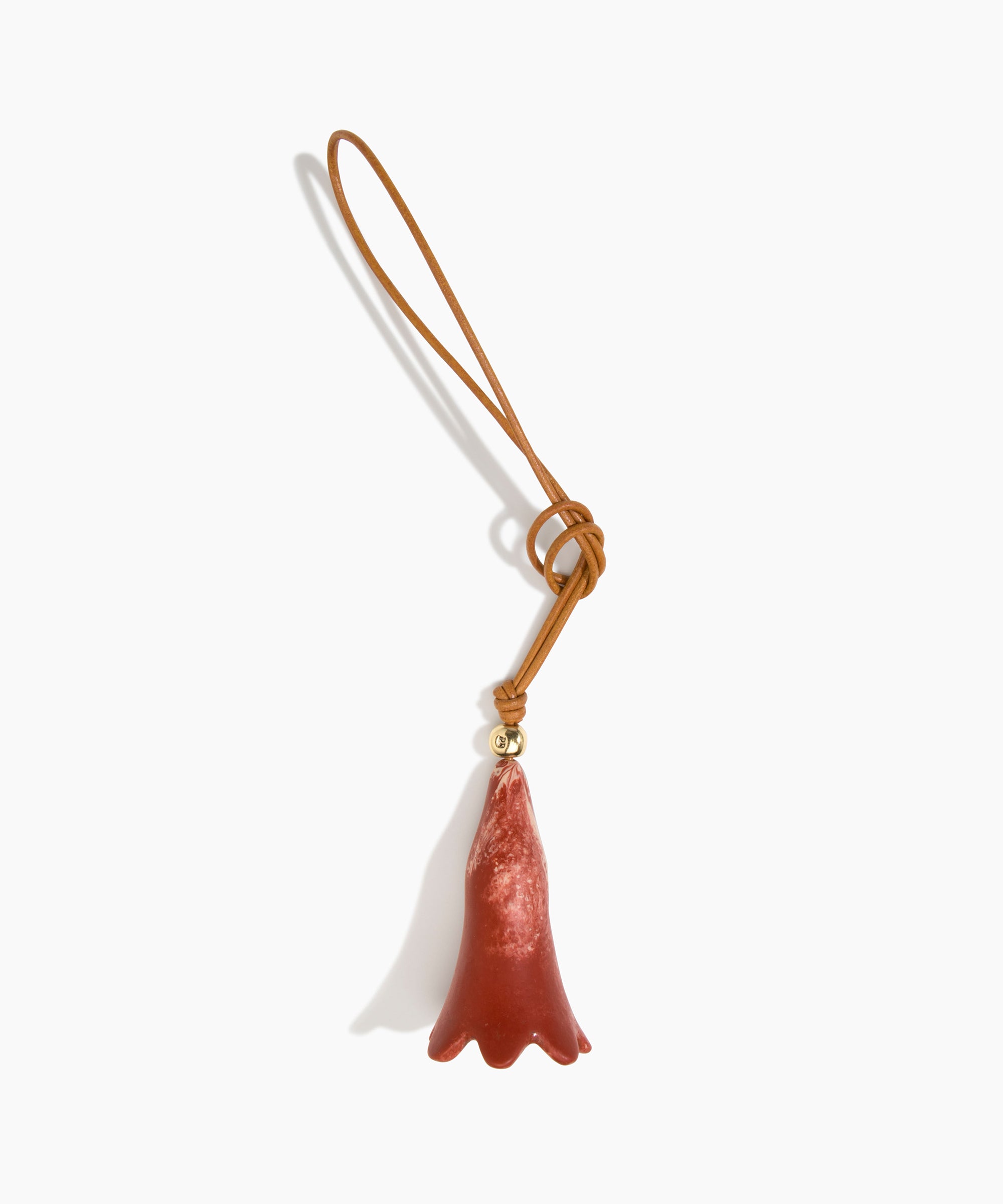 Dinosaur Designs Long Flower Bag Charm in Rust colour with Brass bead — handcrafted marbled terracotta red and cream resin bell-shaped flower bag charm with tan leather hanging loop and brass bead