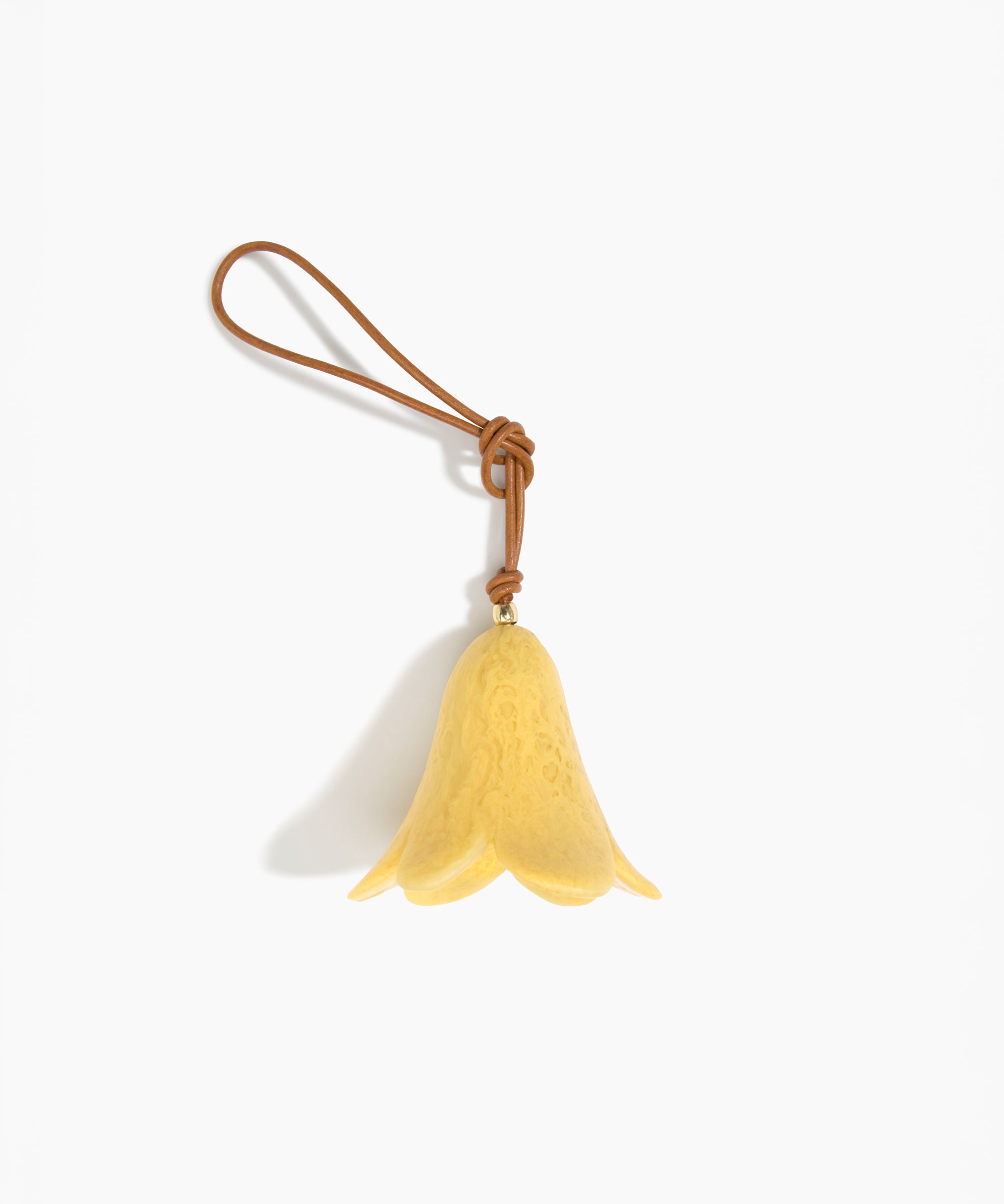 Dinosaur Designs Flower Decoration in Pollen colour with Brass bead — handcrafted marbled yellow resin bell-shaped flower ornament with tan leather hanging loop and brass bead