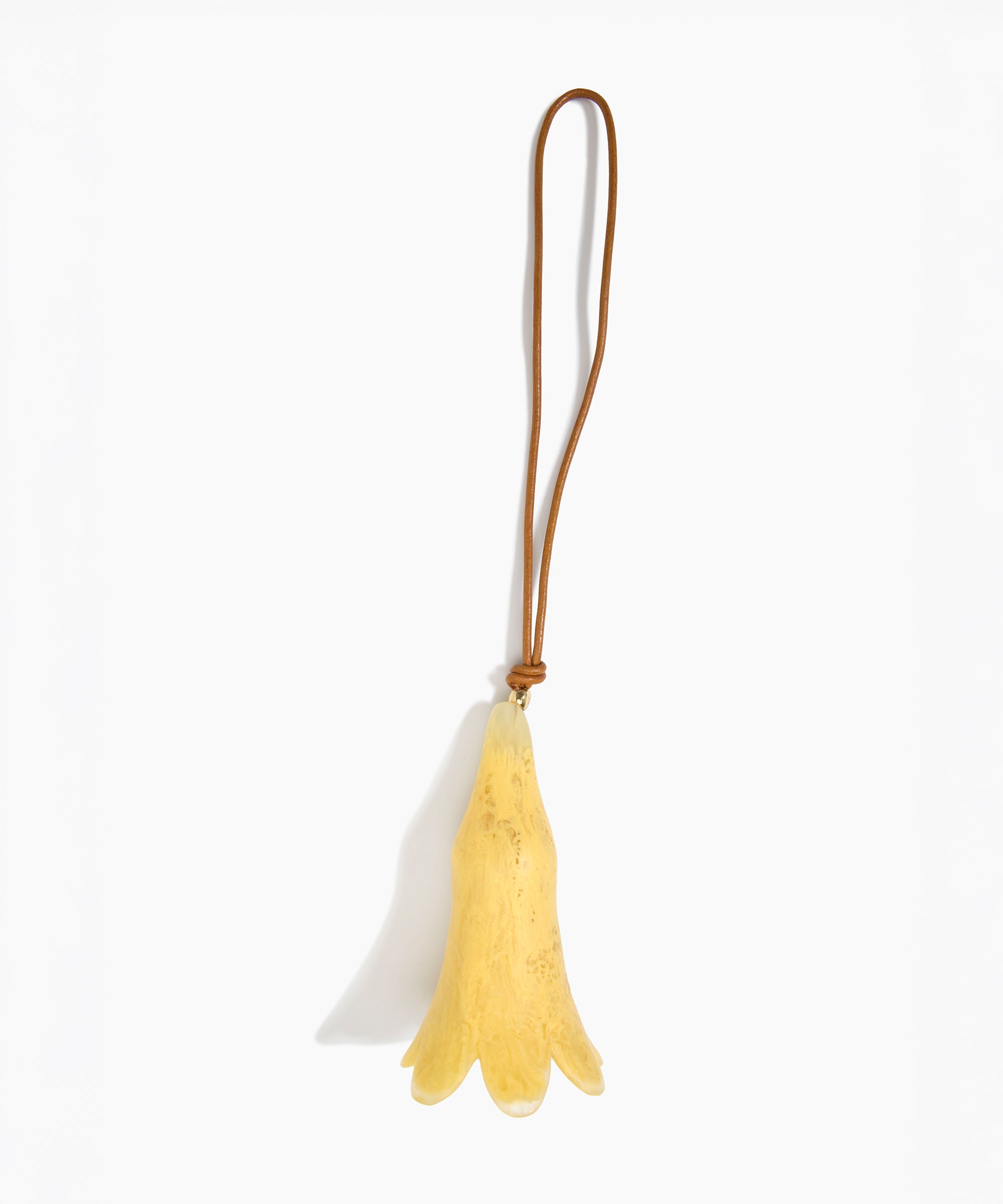 Dinosaur Designs Long Flower Decoration in Pollen colour with Brass bead — handcrafted marbled yellow resin bell-shaped flower ornament with tan leather hanging loop and brass bead