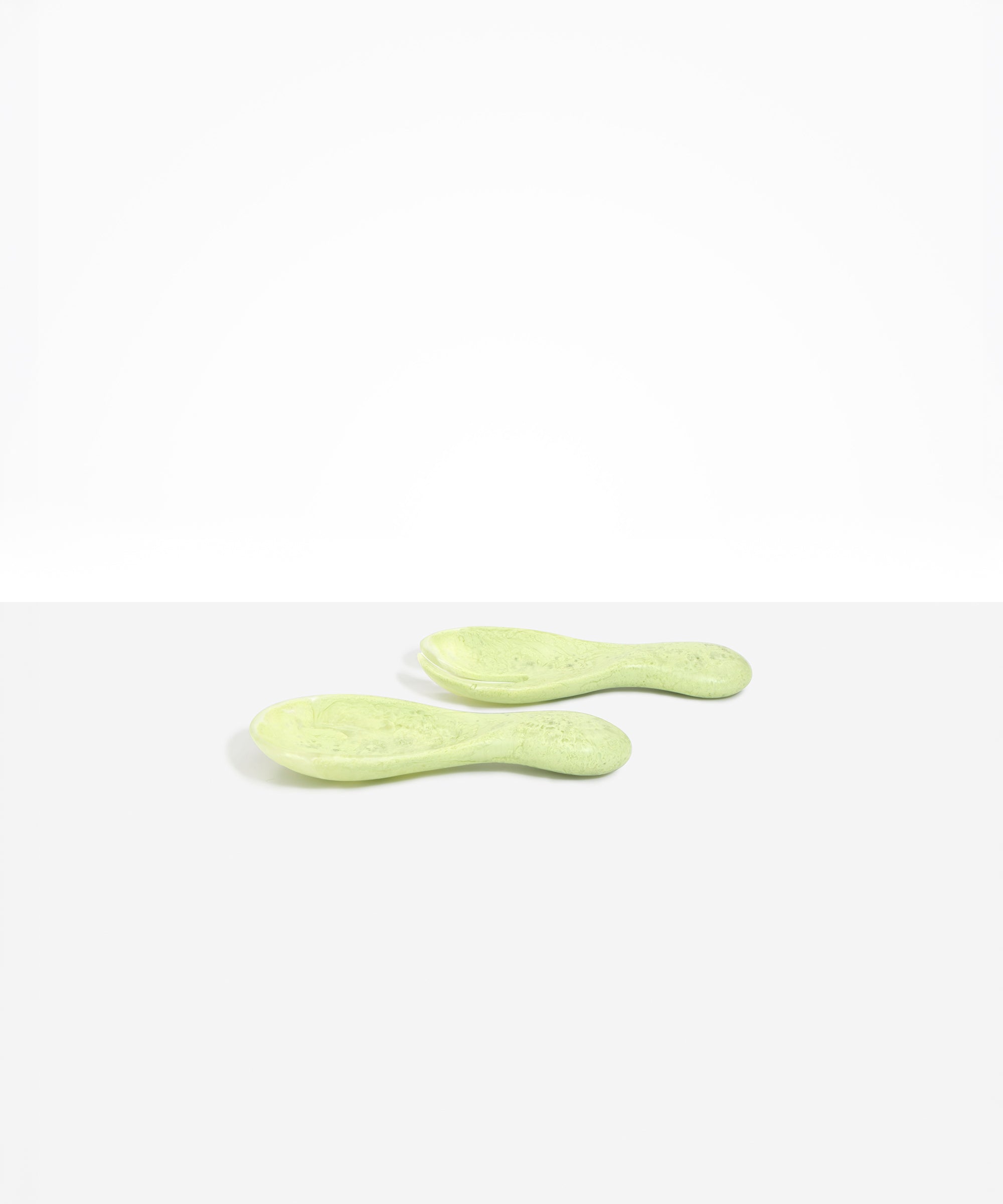 Dinosaur Designs Rock Servers in Pistachio — handcrafted marbled pale green resin salad server set with rounded bulb handles, fork and spoon.