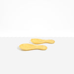 Dinosaur Designs Rock Servers in Pollen — handcrafted marbled yellow resin salad server set with rounded bulb handles, fork and spoon.