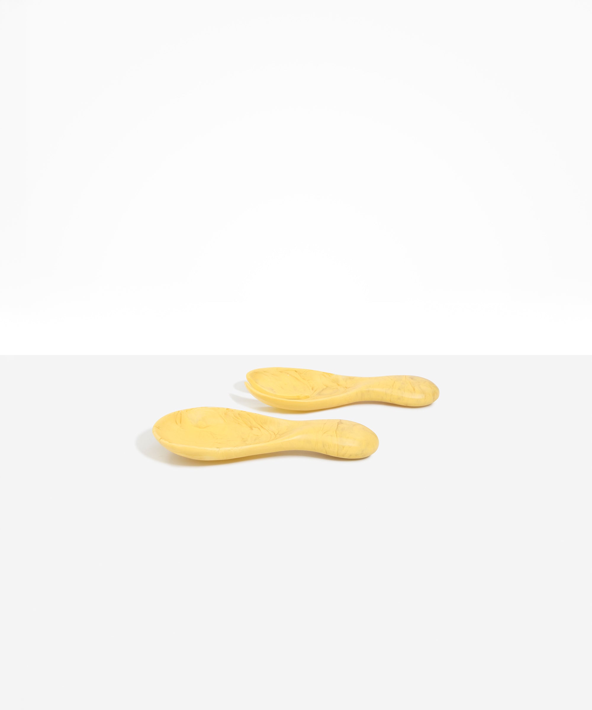 Dinosaur Designs Rock Servers in Pollen — handcrafted marbled yellow resin salad server set with rounded bulb handles, fork and spoon.