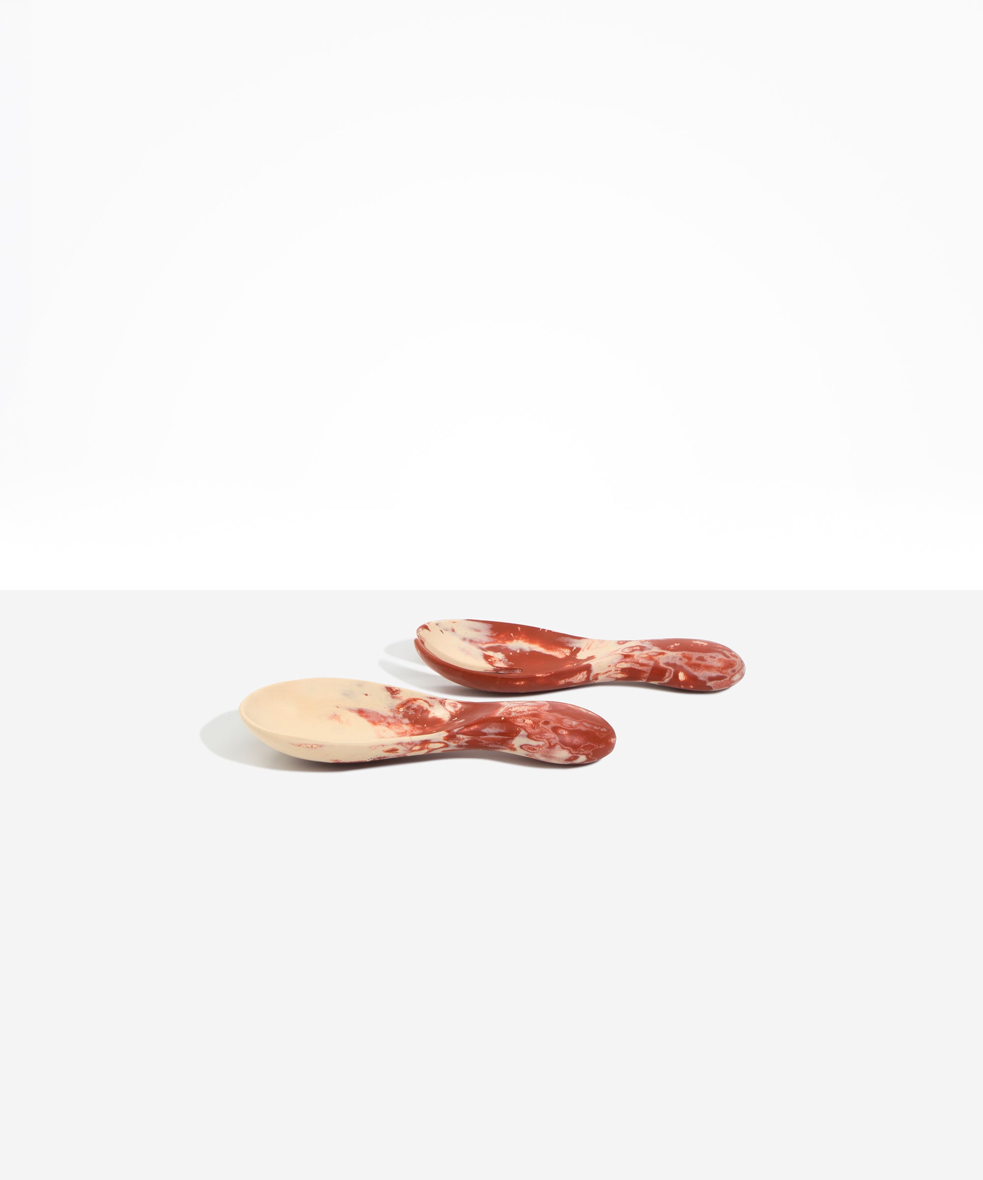 Dinosaur Designs Rock Servers in Rust — handcrafted marbled terracotta red and cream resin salad server set with rounded bulb handles, fork and spoon.