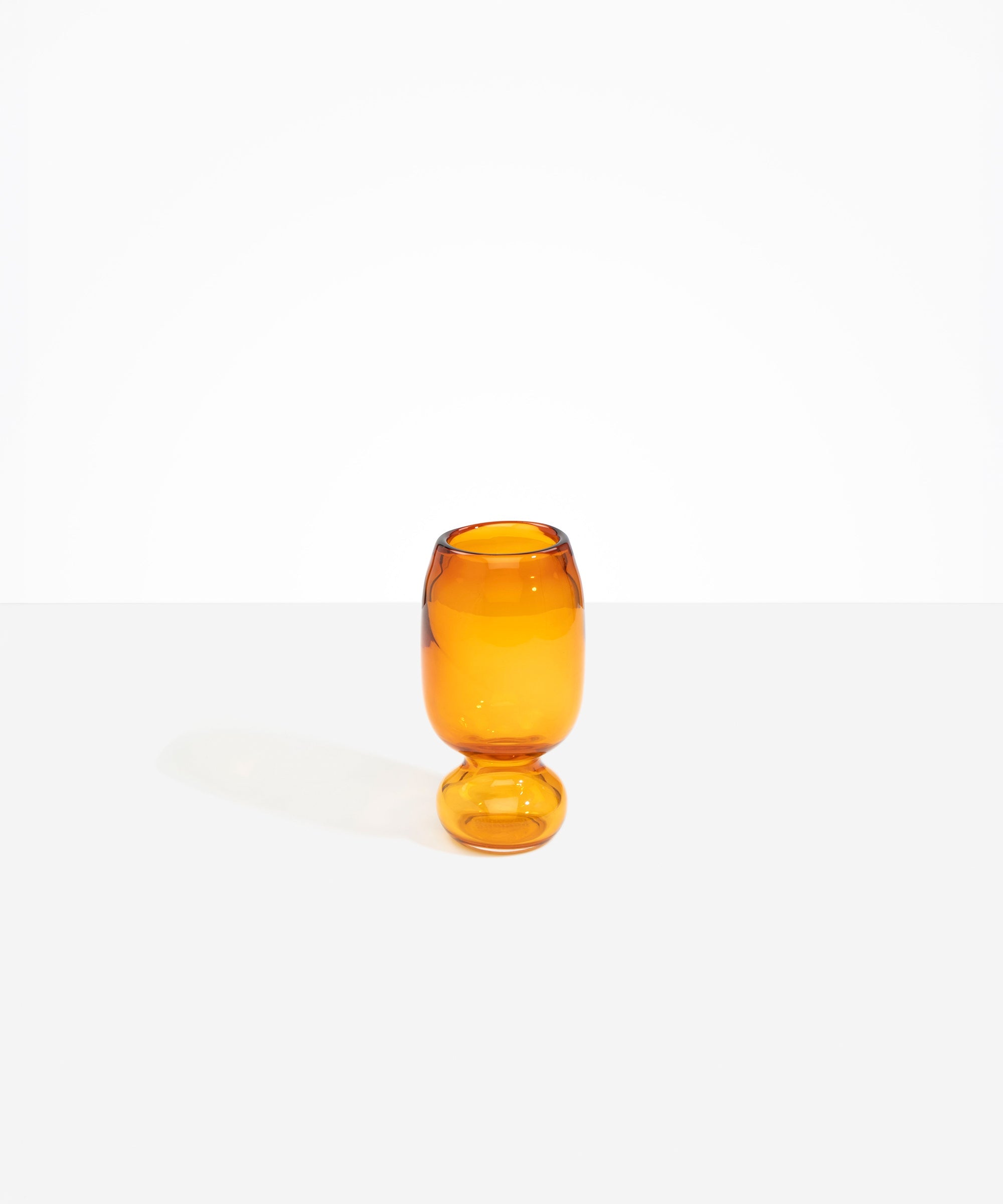 Dinosaur Designs Small Glass Rockpool Vase in Amber — handblown amber glass vase with rounded bulbous body and small spherical pedestal base..
