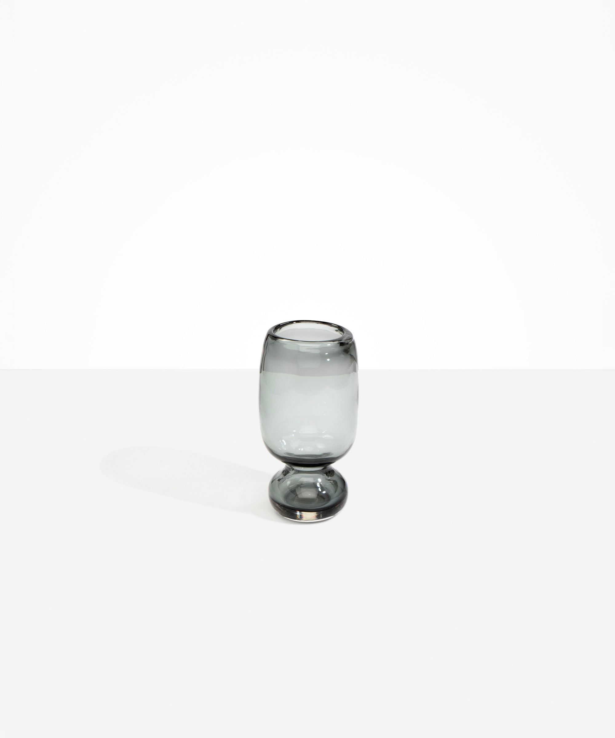 Dinosaur Designs Small Glass Rockpool Vase in Clear Black — handblown transparent black glass vase with rounded bulbous body and small spherical pedestal base..