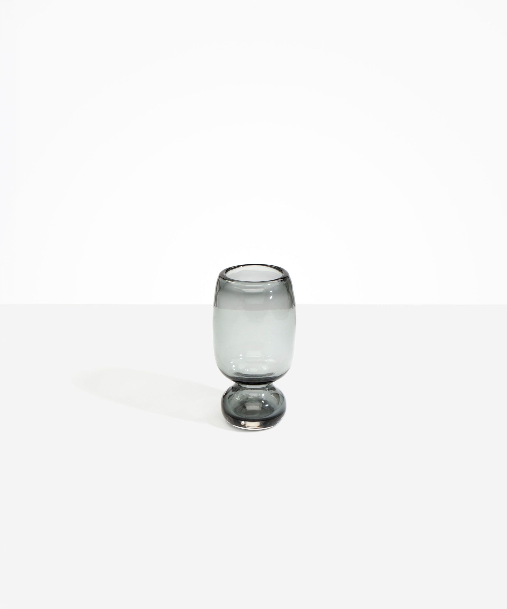 Dinosaur Designs Small Glass Rockpool Vase in Clear Black — handblown transparent black glass vase with rounded bulbous body and small spherical pedestal base..