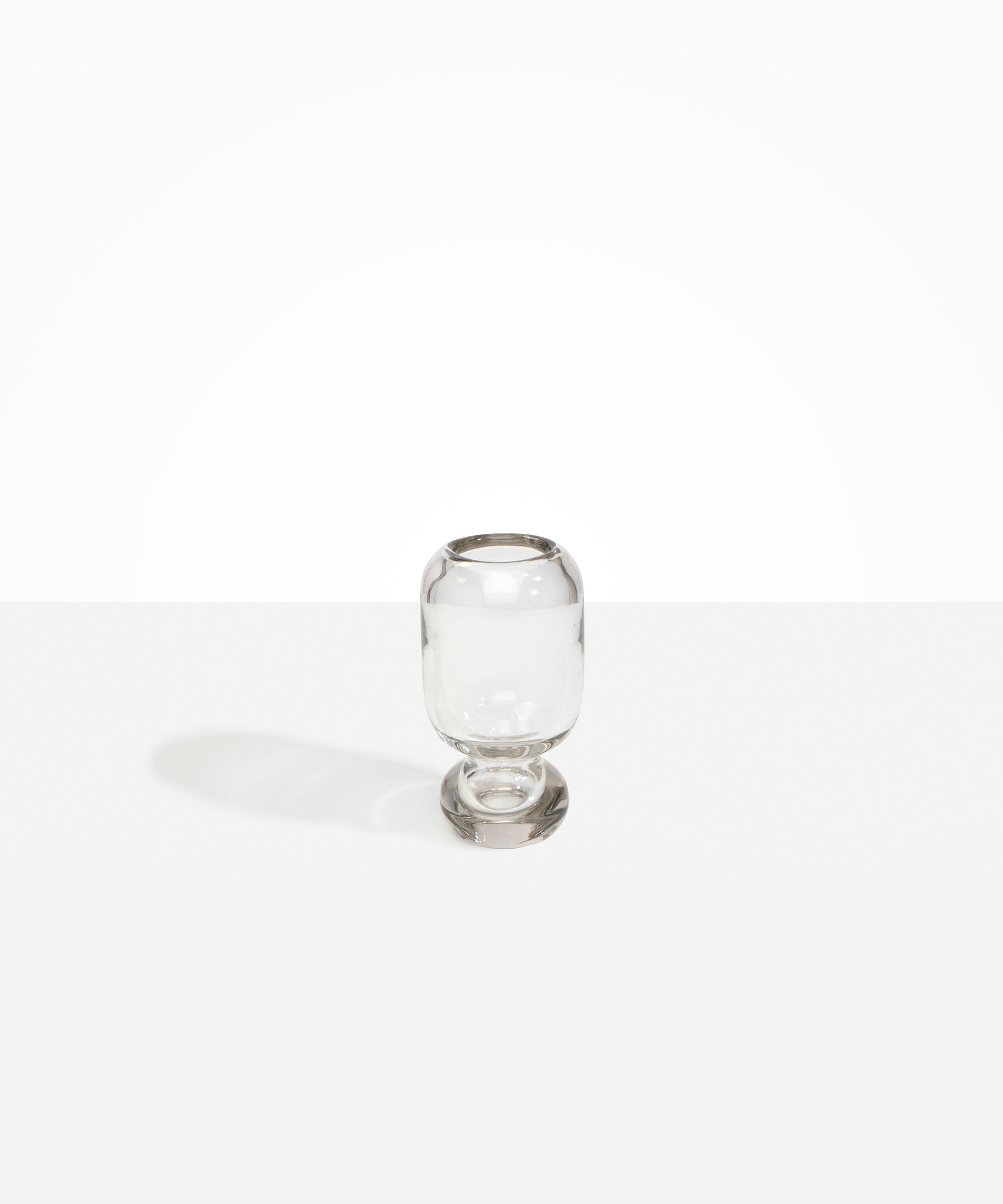 Dinosaur Designs Small Glass Rockpool Vase in Clear — handblown transparent glass vase with rounded bulbous body and small spherical pedestal base..