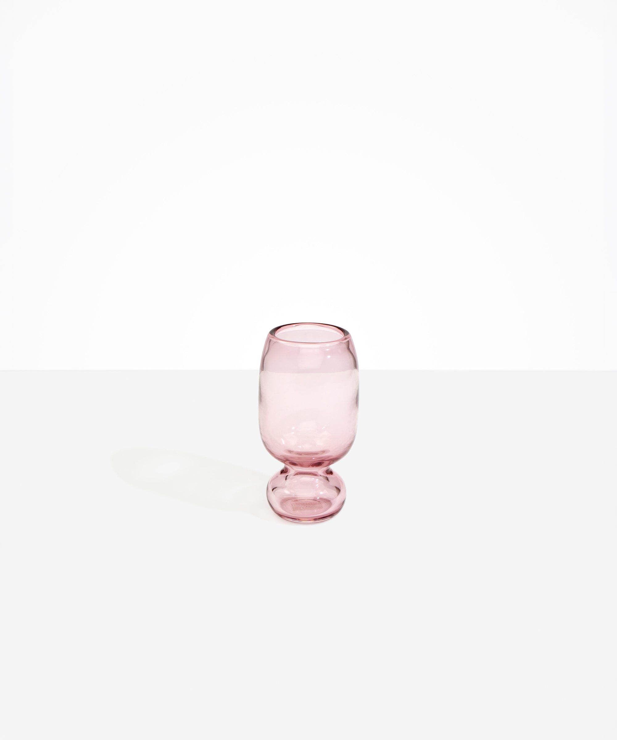 Dinosaur Designs Small Glass Rockpool Vase in Pink — handblown transparent pink glass vase with rounded bulbous body and small spherical pedestal base..