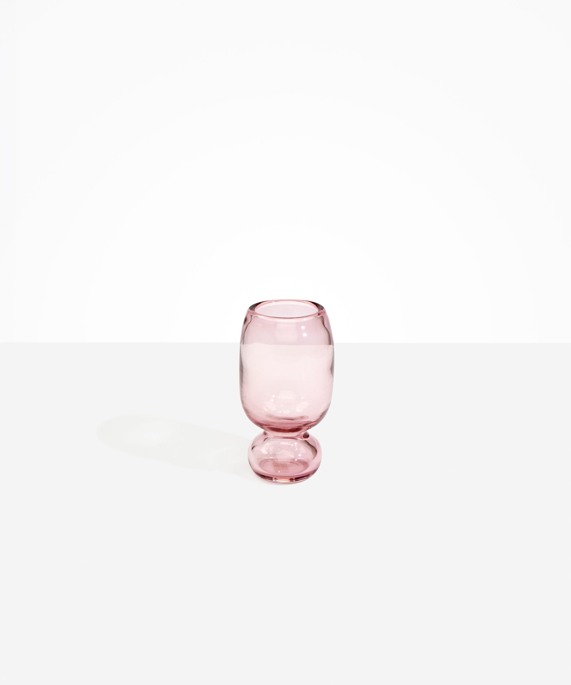 Dinosaur Designs Small Glass Rockpool Vase in Pink — handblown transparent pink glass vase with rounded bulbous body and small spherical pedestal base..