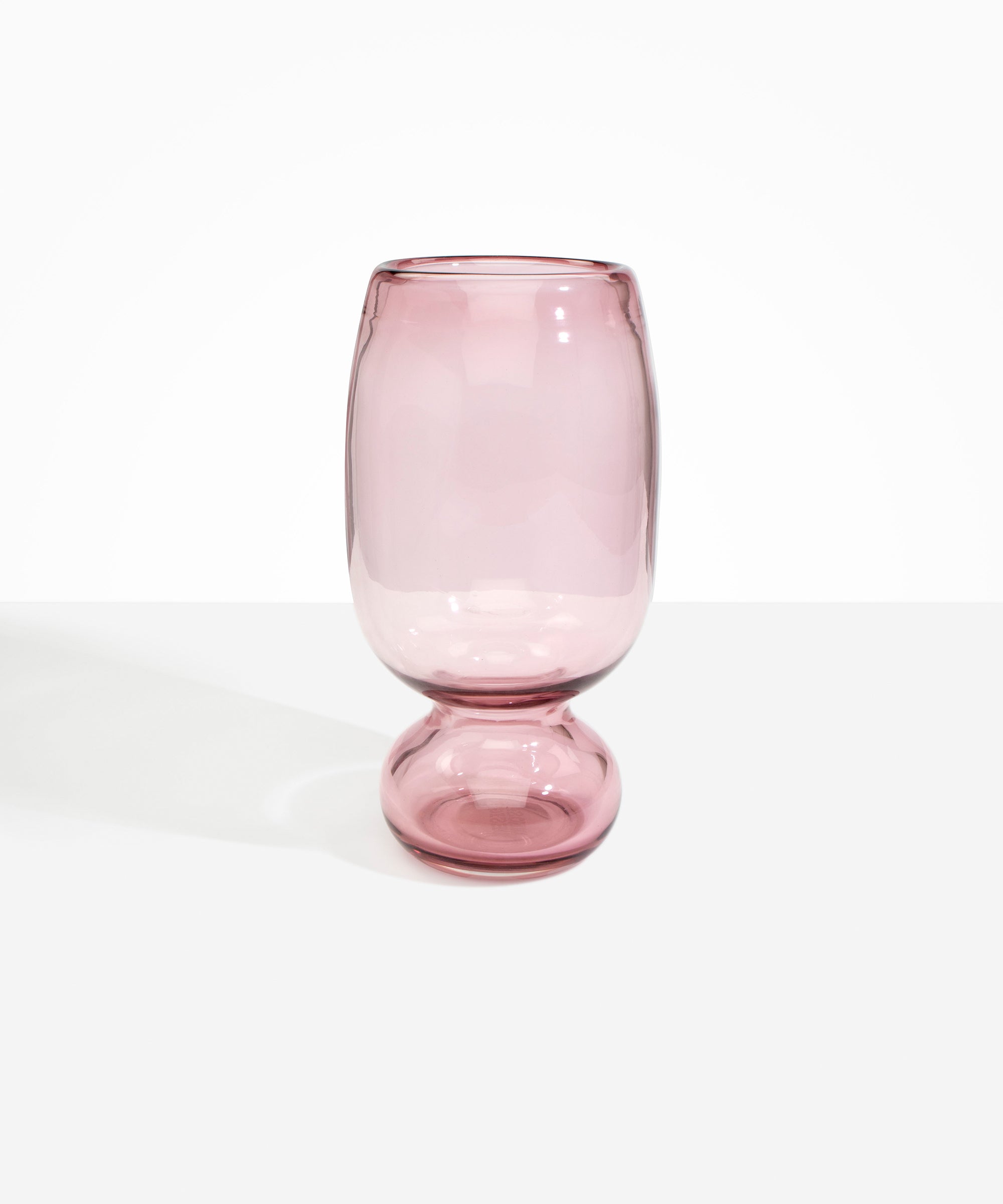 Dinosaur Designs Tall Glass Rockpool Vase in Pink — handblown transparent pink glass vase with rounded bulbous body and spherical pedestal base..